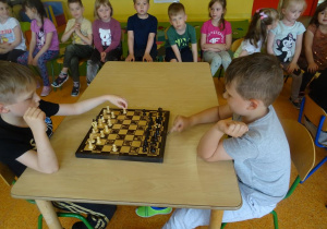 Dwóch chłopców gra w szachy.